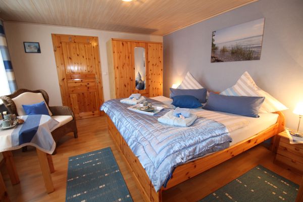 Schlafzimmer blau-wei der Ferienwohnung Lthje in Hochdonn in Dithmarschen am Nord-Ostsee-Kanal mit Doppelbett, Nachttischlampen, Nachttischen, Radiowecker, Herrendiener